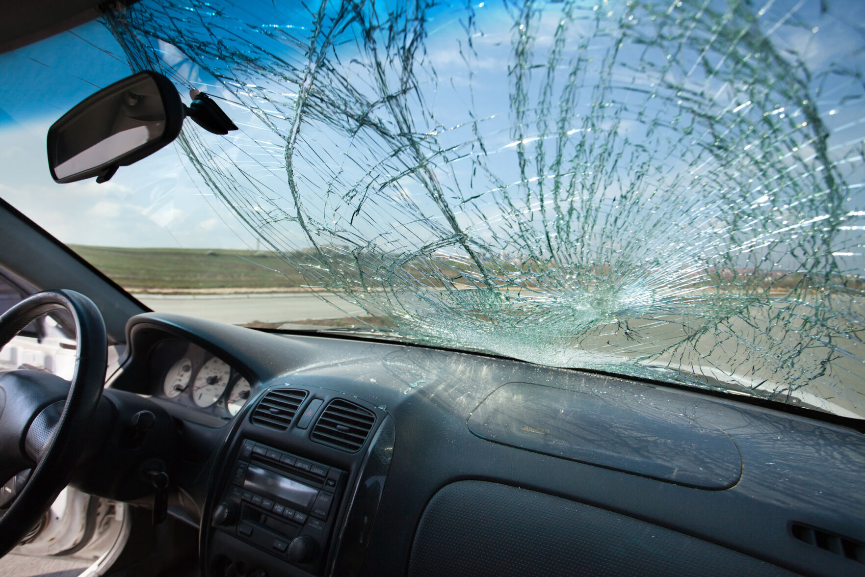 Inside of car with the broken windshield. Road accident
